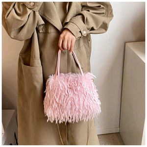 Detailed texture of pink plush handbag with chain strap shown with fashion outfit