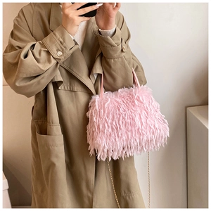 Close-up of pink faux fur crossbody bag featuring elegant gold chain strap and soft texture