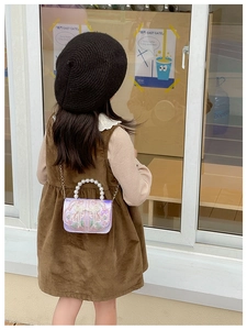 Detail of lavender kids crossbody bag with floral embroidery and pearl handle