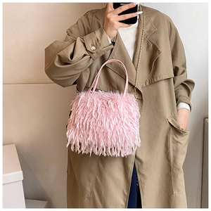 Pink faux fur handbag with gold chain strap styled over a khaki trench coat
