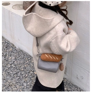 Detailed shot of kids crossbody bag featuring a cute plush baguette bread decoration