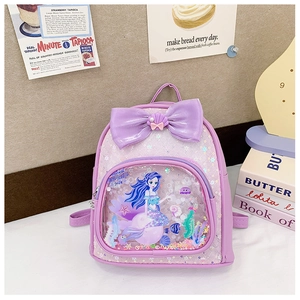 Detail of purple mermaid backpack featuring liquid glitter sand and a large sequin bow