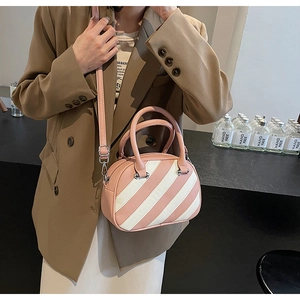 Dettaglio della borsa bowling a righe rosa e bianche con pelle martellata e fibbia