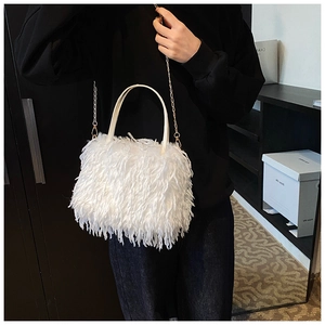 Detail of white fluffy faux fur handbag with leather handle and gold chain strap