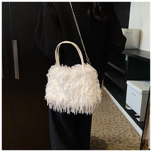 Detail of white feather handbag featuring soft plush texture and a golden chain strap