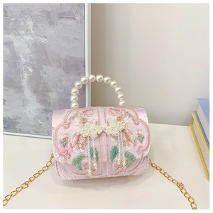 Detailed view of pink satin crossbody bag with flower embroidery and pearl handle