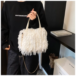 Close-up of fluffy white faux fur handbag with elegant gold chain and thin leather handles