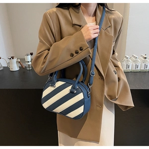 Dettaglio borsa a tracolla a righe blu e beige con trama pelle litchi e cerniera