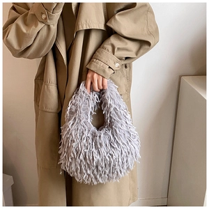 Détail du sac à main en fausse fourrure grise porté par un mannequin en trench-coat kaki