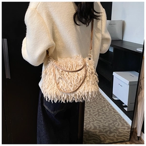 Detailed back view of a soft off-white faux fur crossbody bag with thin shoulder strap