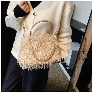 Detailed view of beige plush faux fur handbag with leather handle and metal chain strap