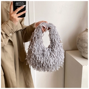 Détails de texture d'un sac hobo en peluche grise avec anneaux en métal et fourrure douce