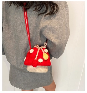 Detail of handmade mushroom crochet shoulder bag with white dots and drawstring strap