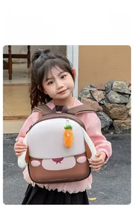 Détail d'un sac à dos lapin pour enfant avec oreilles et charm carotte en peluche