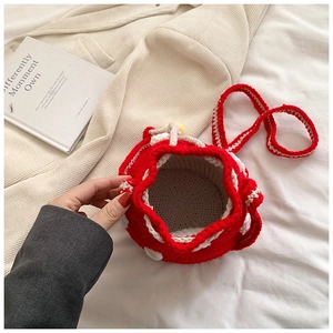 Macro shot of red handmade crochet mushroom bucket bag with white polka dots texture