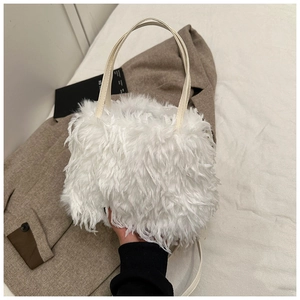 Close-up of white fluffy faux fur handbag with stylish leather handles and soft texture