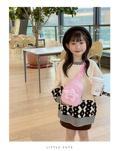 Marsupio rosa per bambini con stella di peluche mostrato in un ambiente di caffè