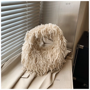 Gros plan détaillé d'un sac à chaîne en peluche blanc crème montrant sa texture douce
