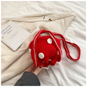 Detail of handmade crochet mushroom bucket bag with red and white polka dot pattern