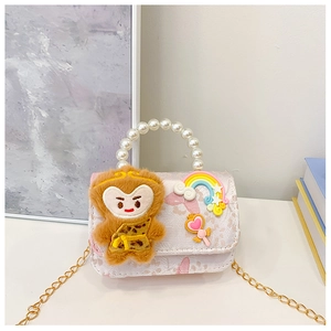 Detail of pink floral handbag with pearl handle, monkey plush and gold chain strap