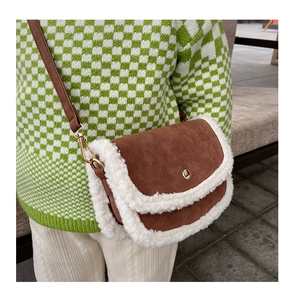 Detail of children's brown suede crossbody bag with soft white faux fur trim and gold clasp