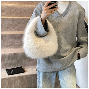 Sac à main blanc en fausse fourrure montré en selfie pour illustrer la taille et la texture