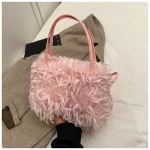 Pink fluffy faux fur handbag with leather double handles in a soft lifestyle setting