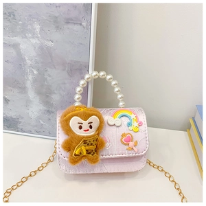 Detail of pink satin girl's purse with cartoon monkey, pearl handle and gold chain