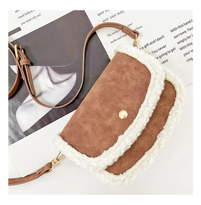 Close-up of brown frosted leather bag featuring white fleece edges and golden metal button
