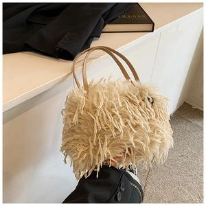 Detailed view of plush cream faux fur handbag with chain strap and leather handle