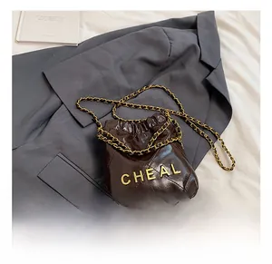 Detail der braunen gesteppten Tasche mit goldener CHEAL-Buchstabenkette und Kordelzug