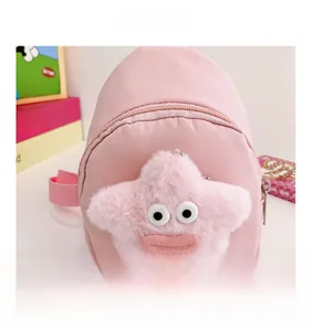 Dettaglio del borsello rosa per bambini con stella di peluche e divertente faccia a cartone