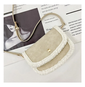 Close-up of beige suede kids crossbody bag with white fleece trim and gold buckle detail