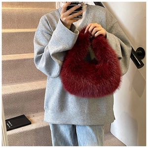 Détail du sac à main en fausse fourrure bordeaux avec texture douce et forme de croissant