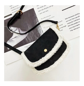 Detail view of mini crossbody bag with black body and white faux fur trim and gold buckle
