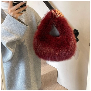 Détails de la texture du sac à main bordeaux en fausse fourrure et de sa anse douce