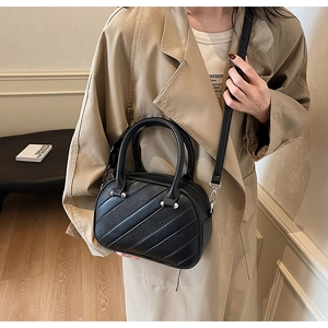 Modello con borsa Boston nera con trapuntatura diagonale e dettagli in argento