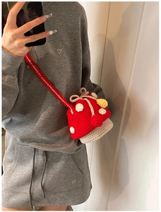Detail of handmade crochet mushroom shoulder bag with red cap and white polka dots for kids