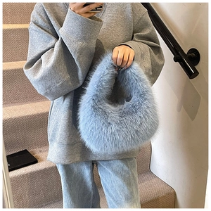 Détail d'un sac à main en peluche bleu clair montrant la texture douce et le design nuage