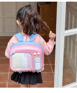 Sac à dos rigide TV rétro rose et bleu porté par une petite fille vue de dos