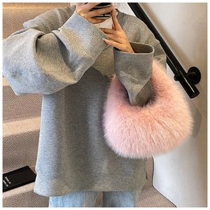 Texture détaillée du sac à main en fausse fourrure rose assorti à un sweat à capuche gris