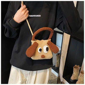 Detailed view of a handmade crochet cartoon dog crossbody bag with 3D ears on a model