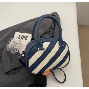Vista dall'alto di una borsa in pelle bicolore con eleganti strisce blu e beige chic