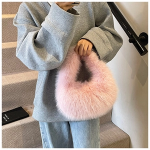 Gros plan du sac à main en fausse fourrure rose assorti à un sweat-shirt gris décontracté