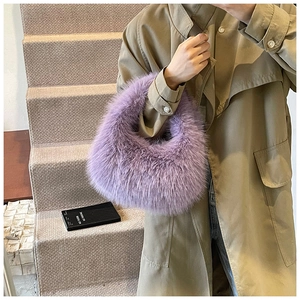 Détail de la texture d'un sac à main violet en fausse fourrure porté par un mannequin