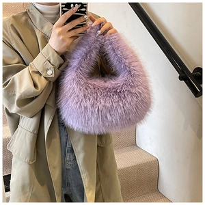 Gros plan d'un sac à main en fausse fourrure violette porté avec un trench kaki