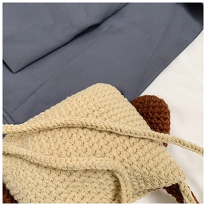 Detailed view of handmade crochet shoulder bag featuring thick yarn texture and animal ears