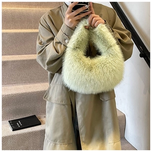 Gros plan du sac à main en fausse fourrure vert clair montrant la texture douce et l'anse