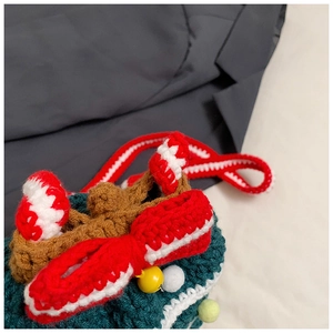Close-up of handmade crochet Christmas tree bag with red bow and gold bell details