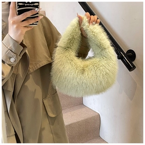Détail du sac à main en peluche vert pistache porté par un mannequin en décor extérieur